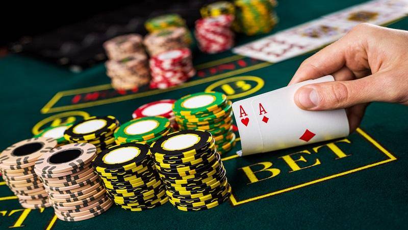 德州撲克玩家手持AA底牌與籌碼堆疊｜Texas Hold’em Poker賭桌策略